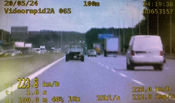 Kadr z filmu przedstawiający ciemny samochód i pomiar prędkości - 223 km/h